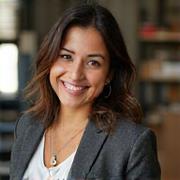 Retrato de la Fotógrafa Laura Mendoza, con cámara al cuello, sonriendo profesionalmente